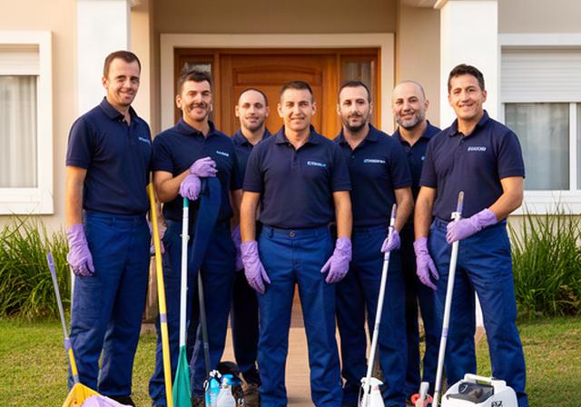 Equipo de Suárez Pulcritud con uniformes azules y elementos de limpieza profesional frente a una vivienda en Laguna Paiva, Santa Fe, mostrando cercanía y profesionalismo local